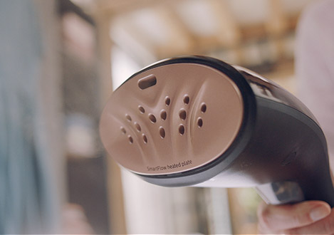 Handheld steamer with heated plate