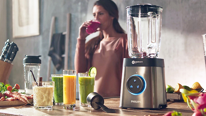 a lady is using the Philips blender