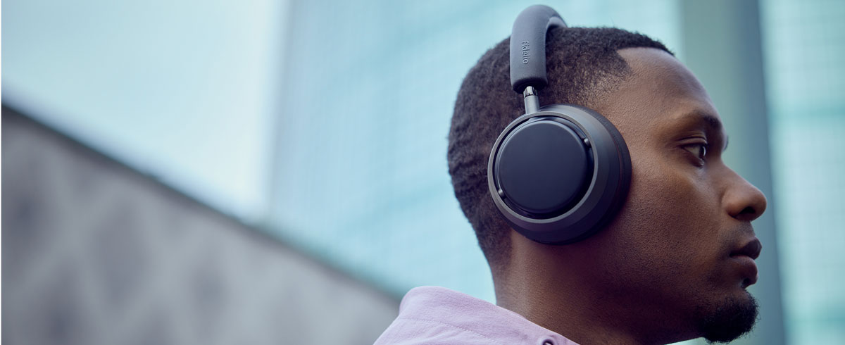 A man is listening to music with Philips X3 headphones.